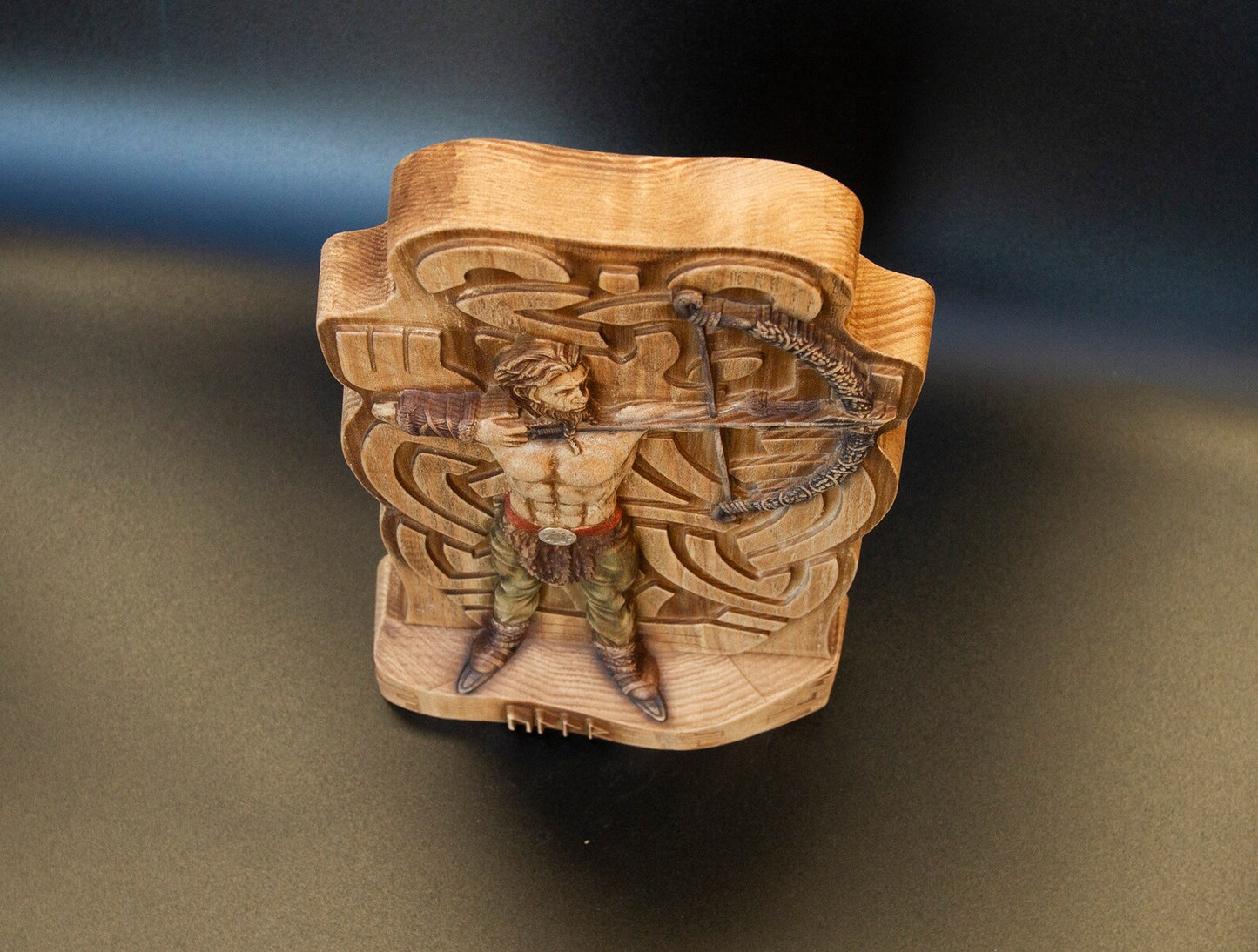 Top view of wooden Ullr figurine, Norse god archer statue with carved bow and Celtic pattern Viking decor.