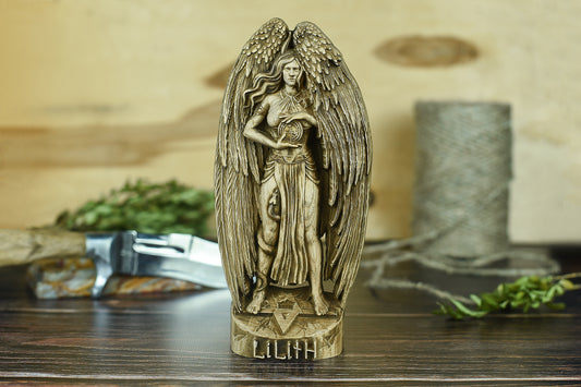 Hand-carved Lilith goddess ash wood statue, 8 inch dark angelic altar figurine with wings and occult symbols, pagan witchcraft decor on wooden table.