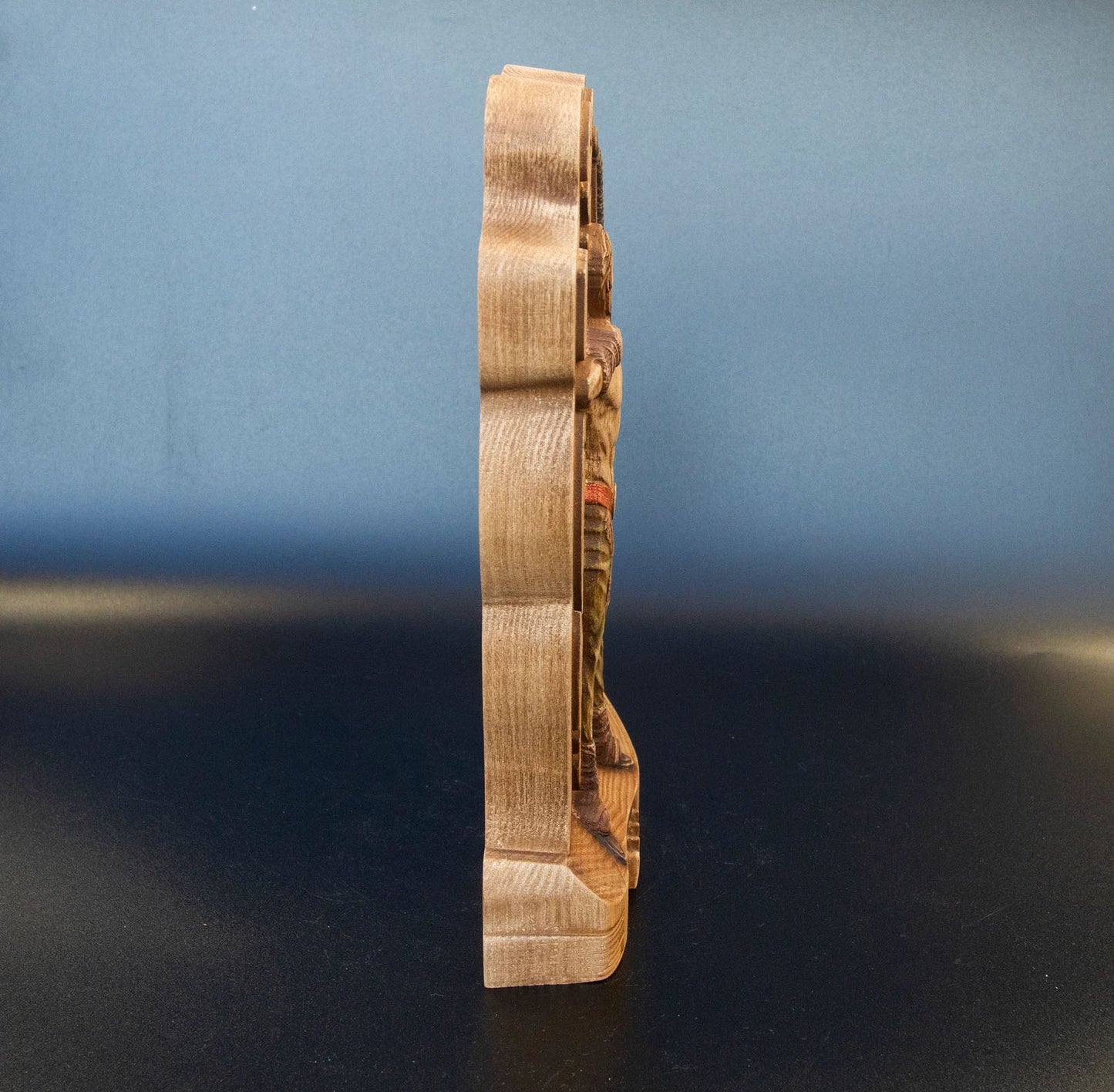Left side profile of wooden Ullr figurine showing carved Norse archer silhouette and natural wood grain Viking statue.
