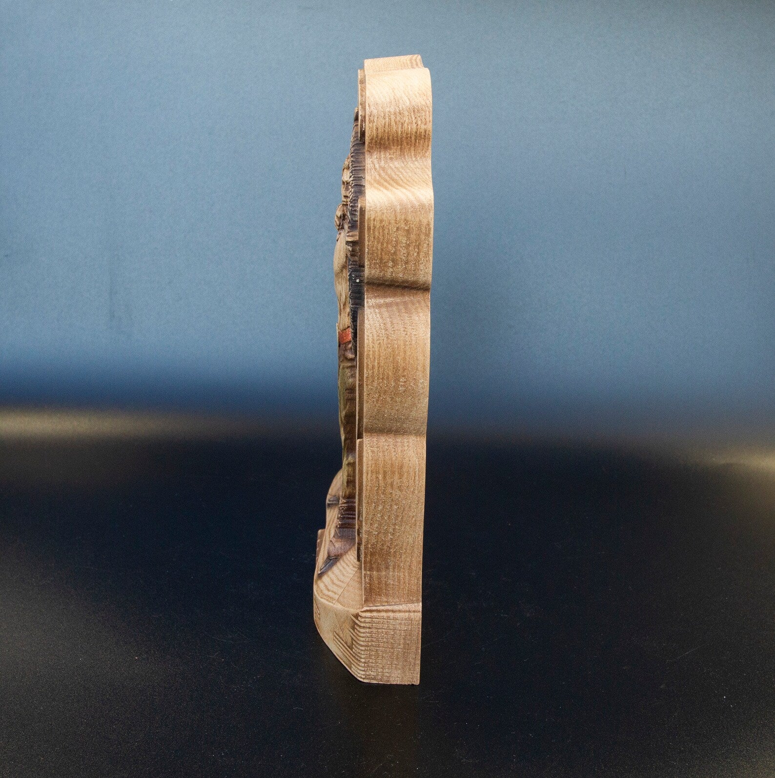 Right side profile of wooden Ullr figurine showing slim carved thickness and natural wood grain Viking statue.